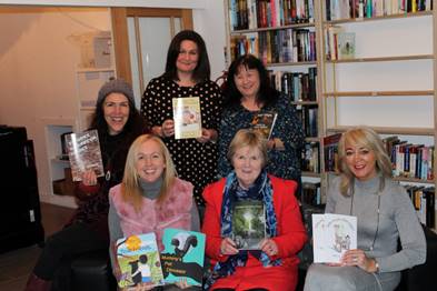 A picture containing indoor, book, shelf, person

Description automatically generated